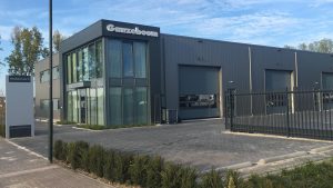 Ganzeboom-gebouw met zichtbare tekst Ganzeboom, bord 'Handelsstraat 3' en 'www.ganzeboom.net' bij oprit en gesloten poort.