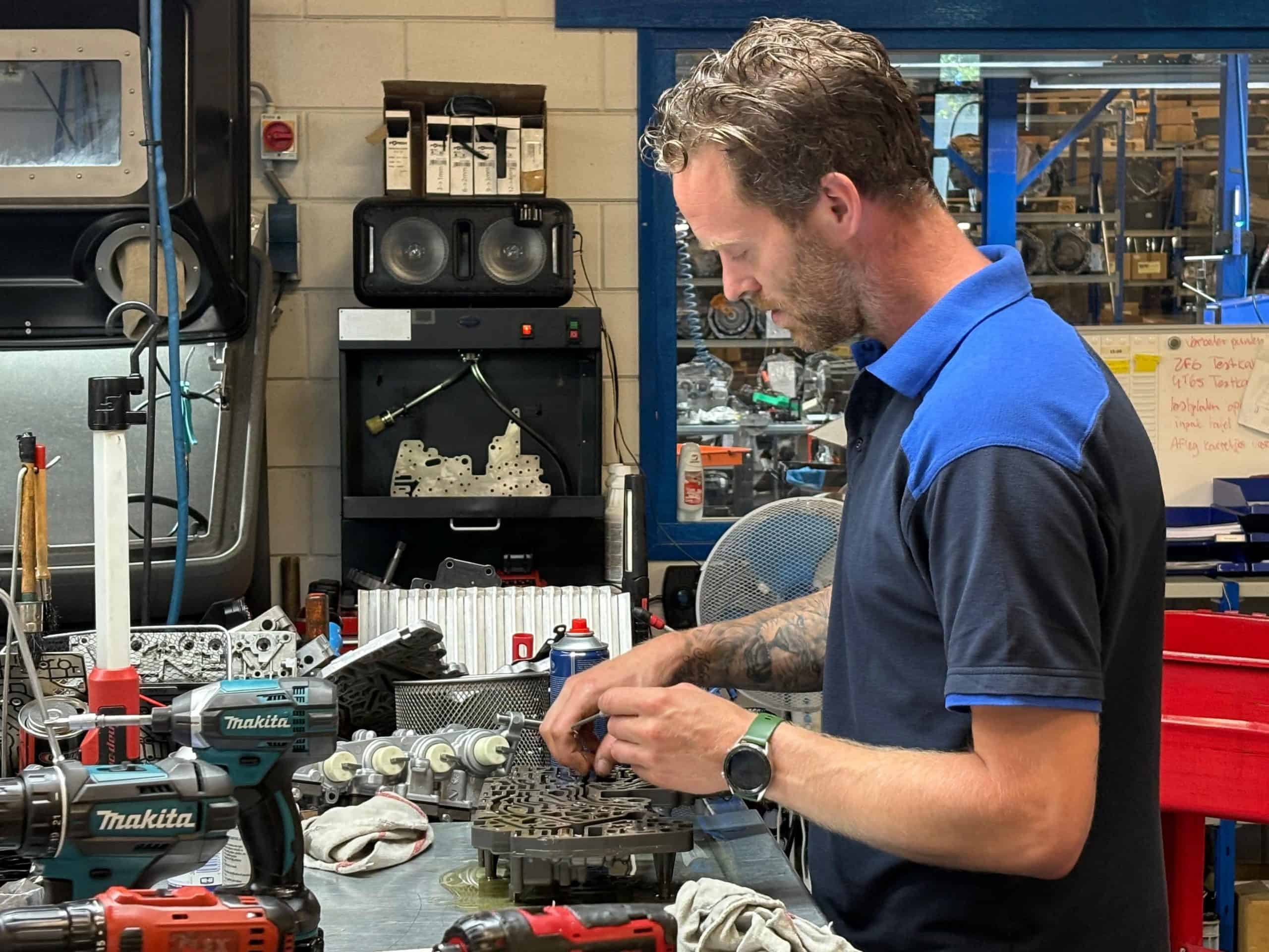 Monteur die handmatig een versnellingsbak reviseert.