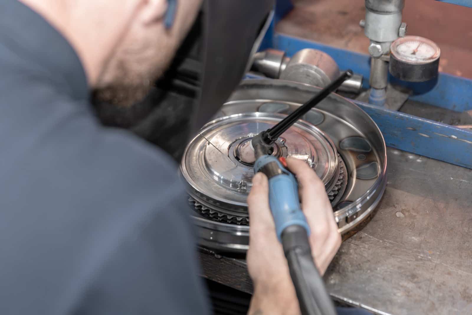 Een geopende koppelomvormer wordt bewerkt in de werkplaats van Ganzeboom