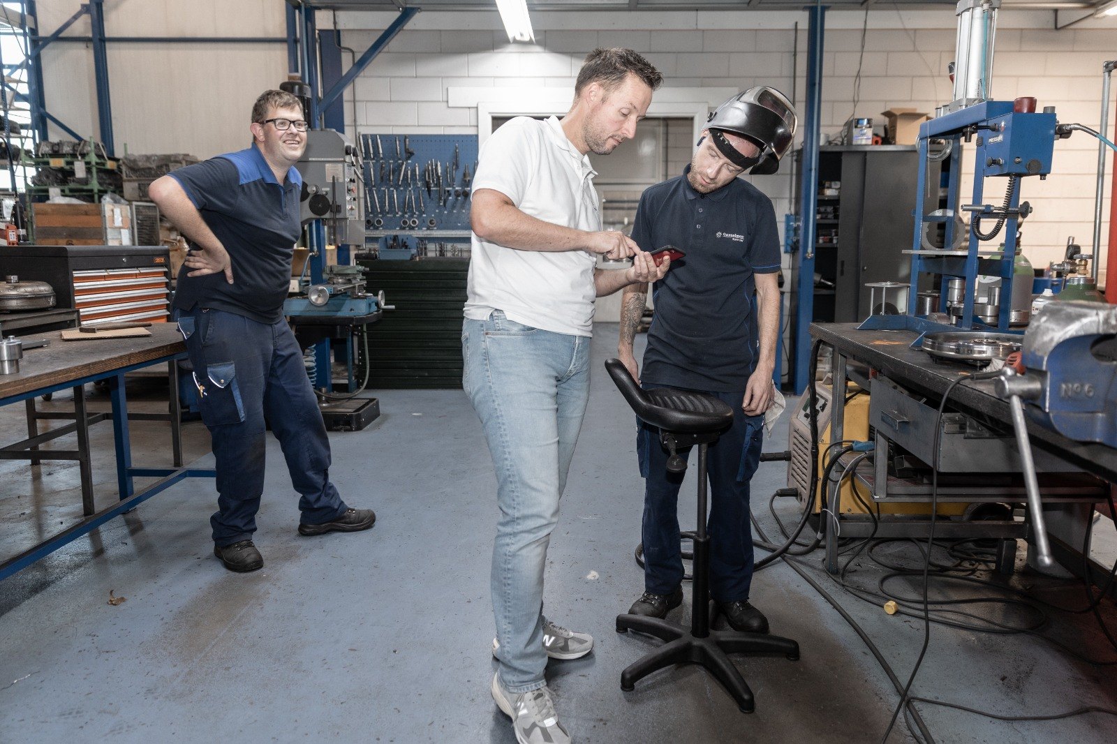 Drie medewerkers van Ganzeboom overleggen in de werkplaats